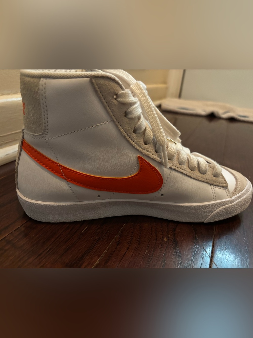 Nike Women’s White High-Top Sneakers with Orange Swoosh Accent